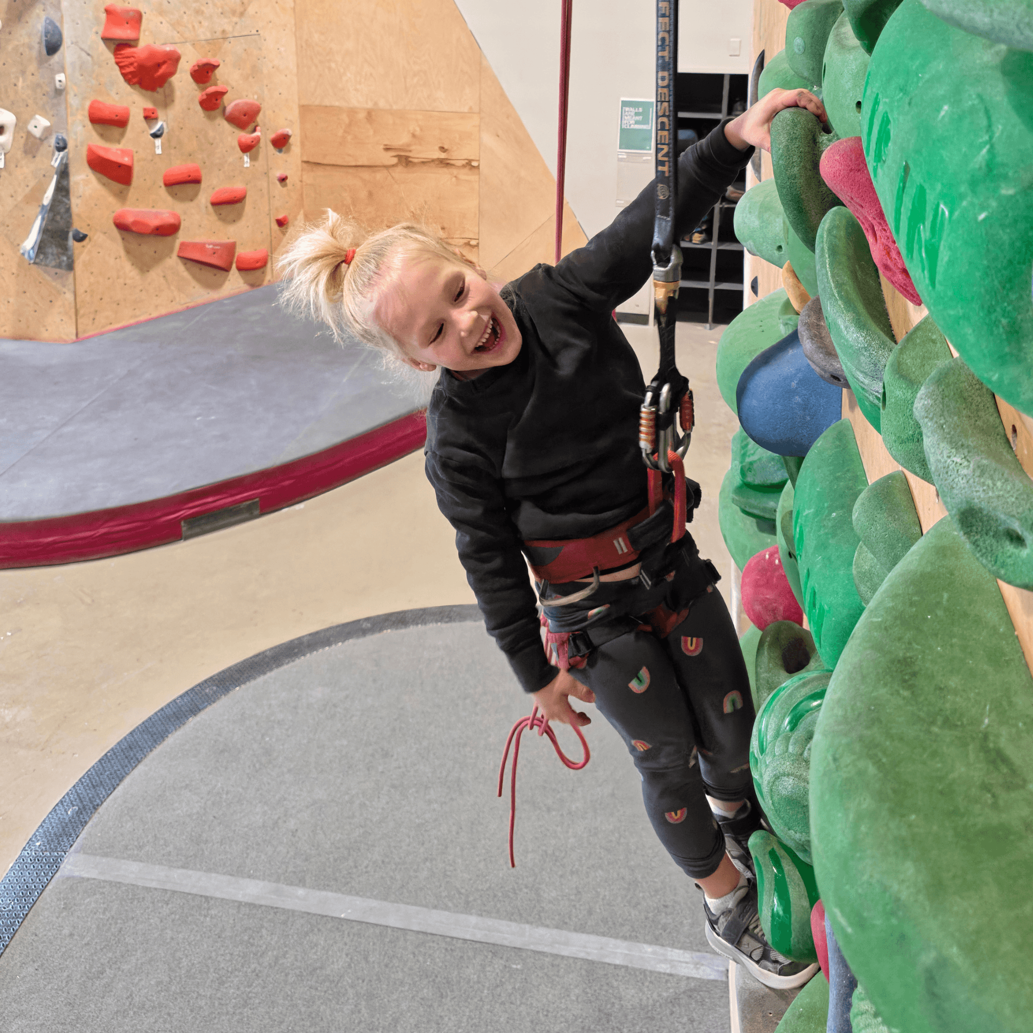Youth climbing coach working with young athletes at the wall