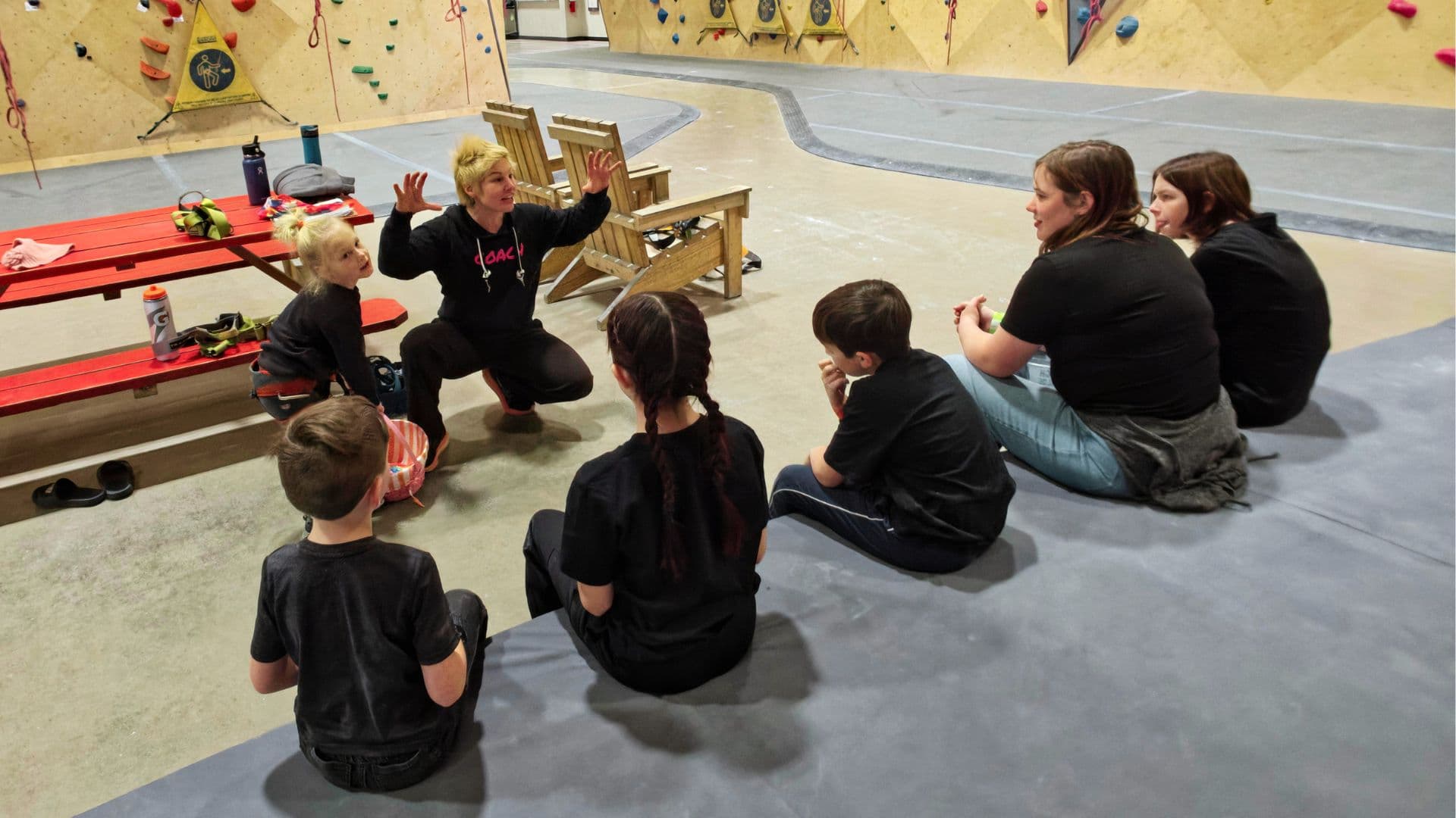 Coach explaining a climbing game to athletes at the wall